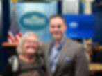 Smiling woman and man at White House briefing
