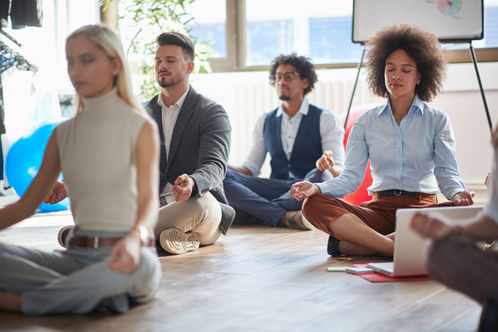 Employees practising mindfulness during a workplace wellbeing session in the office.