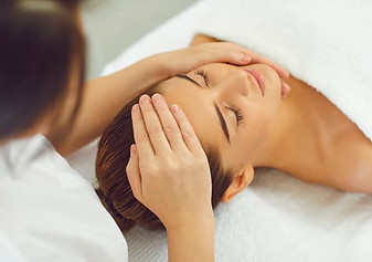 a woman receiving a massage on her head and face during a skin treatment