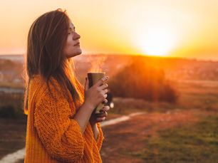 A woman holding a cup of coffee outside