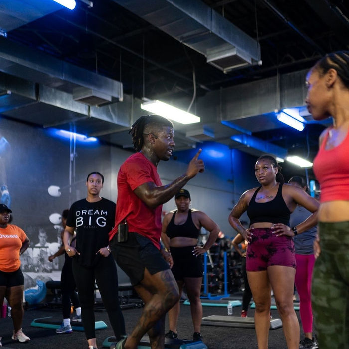 Fitness instructor leading group exercise class