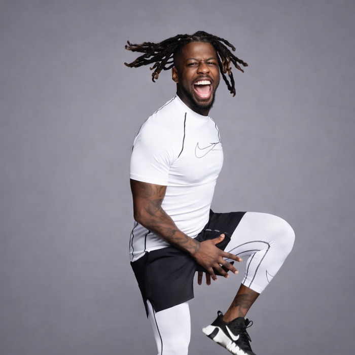 Man with dreadlocks stepping on exercise platform, smiling
