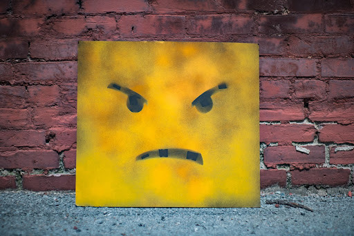 A yellow square with a frowning face on it.