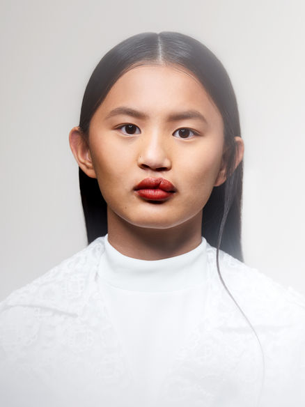  Model met donker haar in een witte coltrui voor witte achtergrond