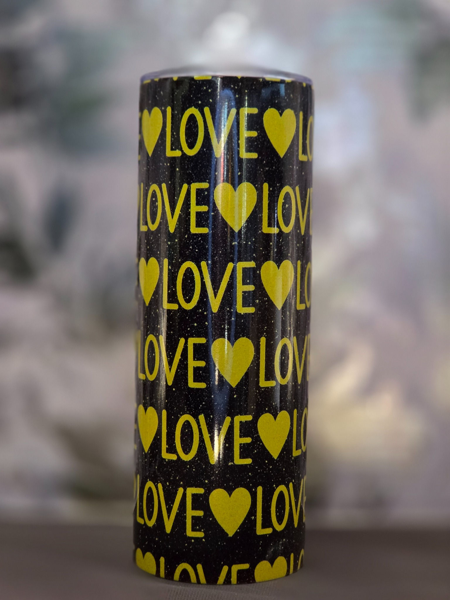 20oz skinny tumbler with yellow LOVE lettering and hearts repeated on black background