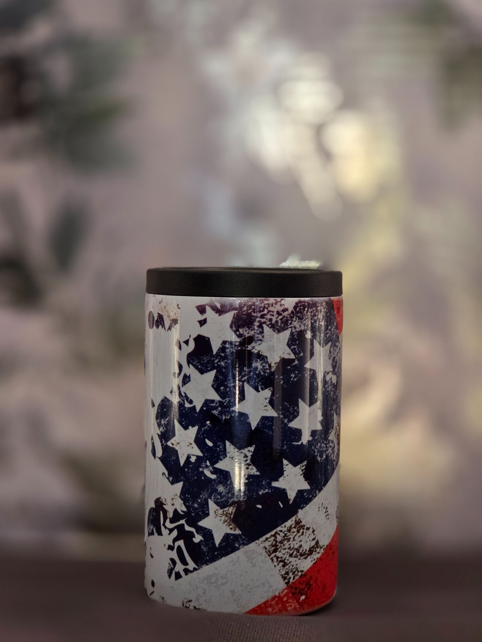 Finished metal can koozie displaying distressed American flag's navy blue field with white stars and red stripe, black top rim