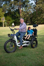 Riding a tricycle at First2Cares annual Picnic in the Park