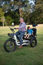 Riding a tricycle at First2Cares annual Picnic in the Park