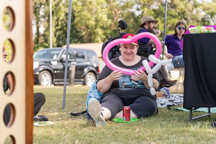 Woman holding up a heart shaped balloon at First2Care's annual Picnic in the Park 2025