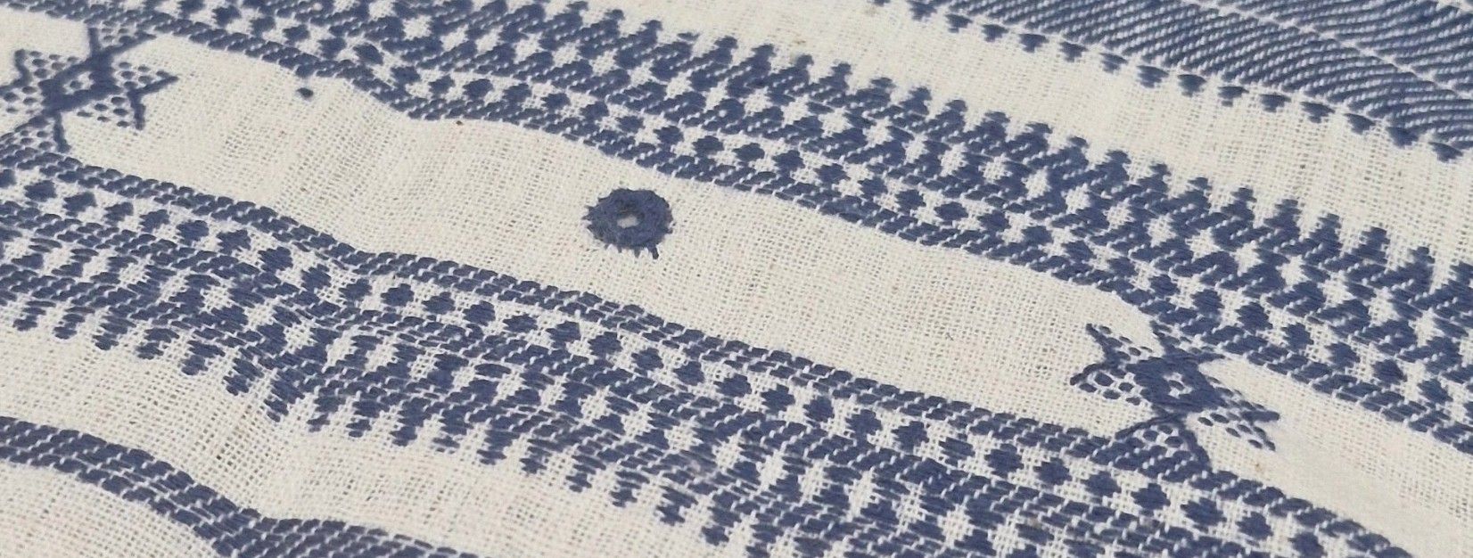 An indigo and white handwoven textile, close up