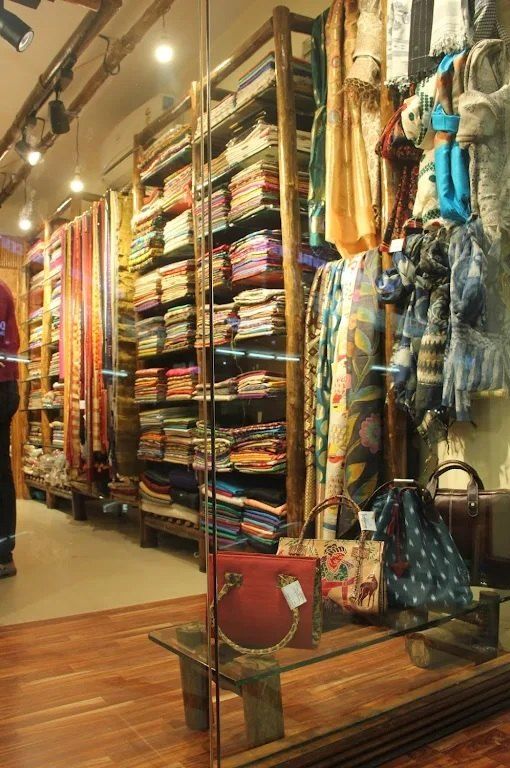 Inside KathaDoi Handloom: shelves of folded handloom saris and stoles