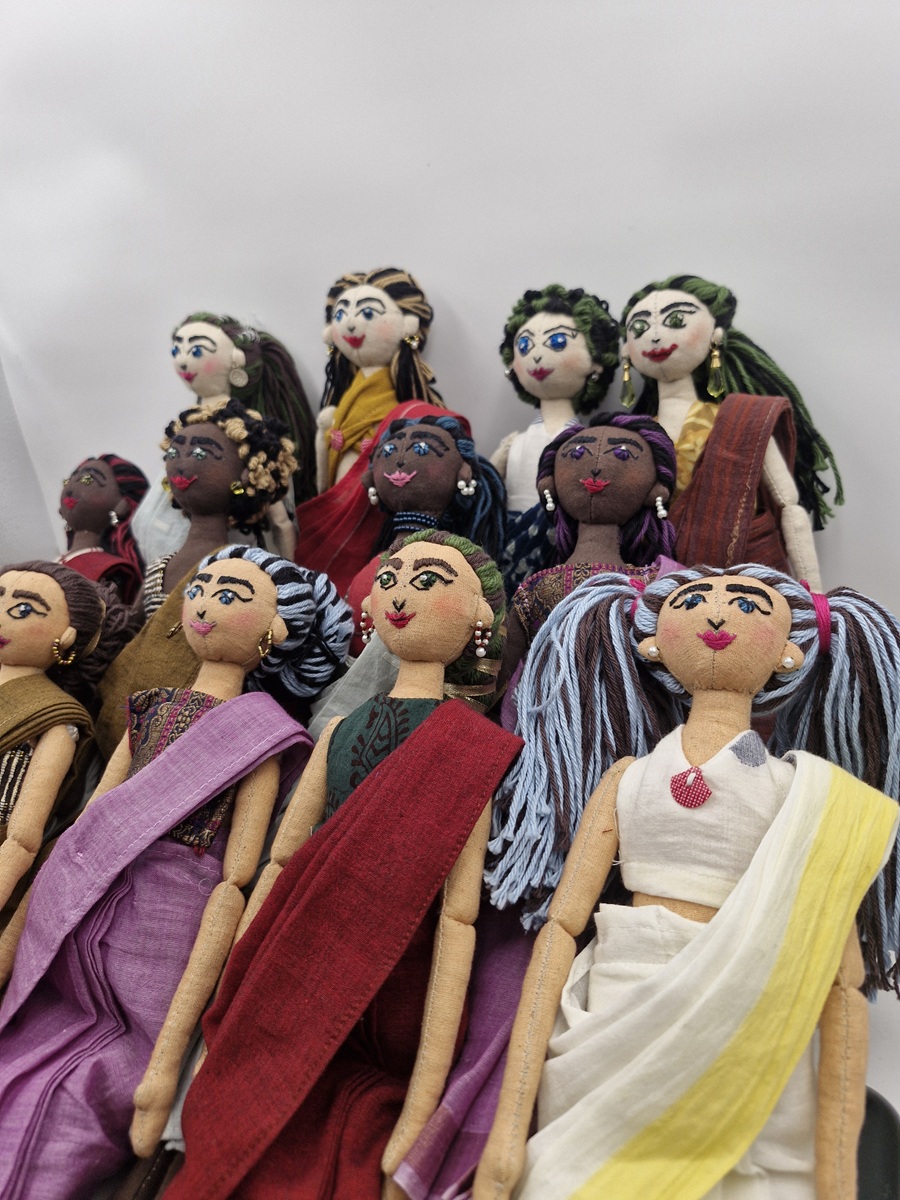 Masakali handmade fabric dolls lying side by side, in handloom saris, with embroidered faces and yarn hair