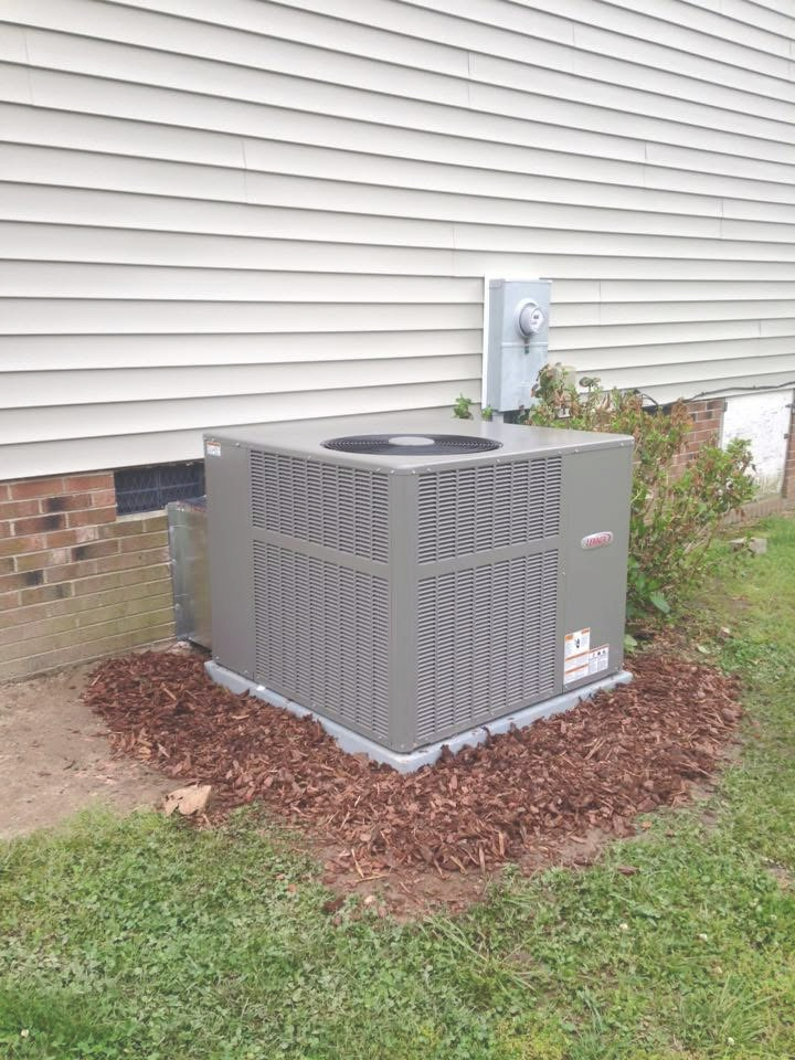 grey HVAC unit outside on mulch