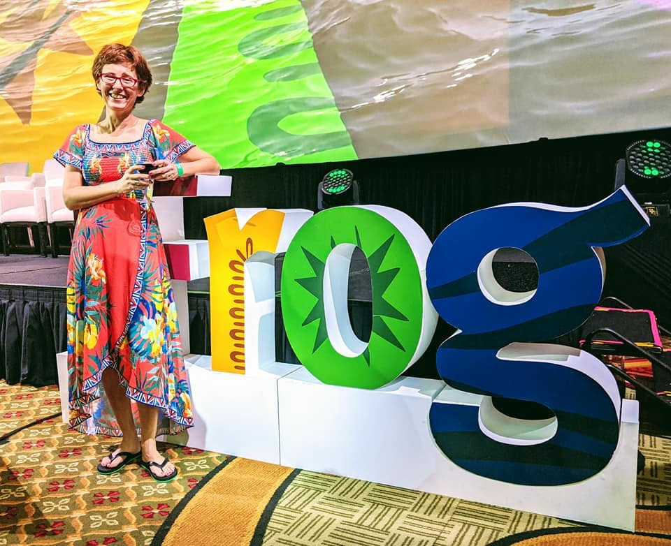 Dana is standing next to a Jfrog sign