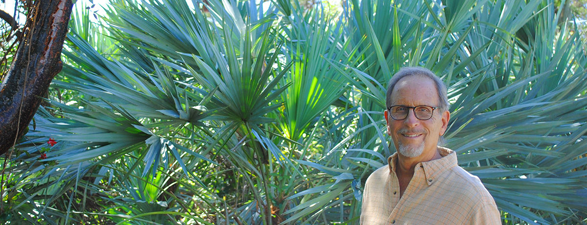 Brian Foster portrait in front of palmetto froms