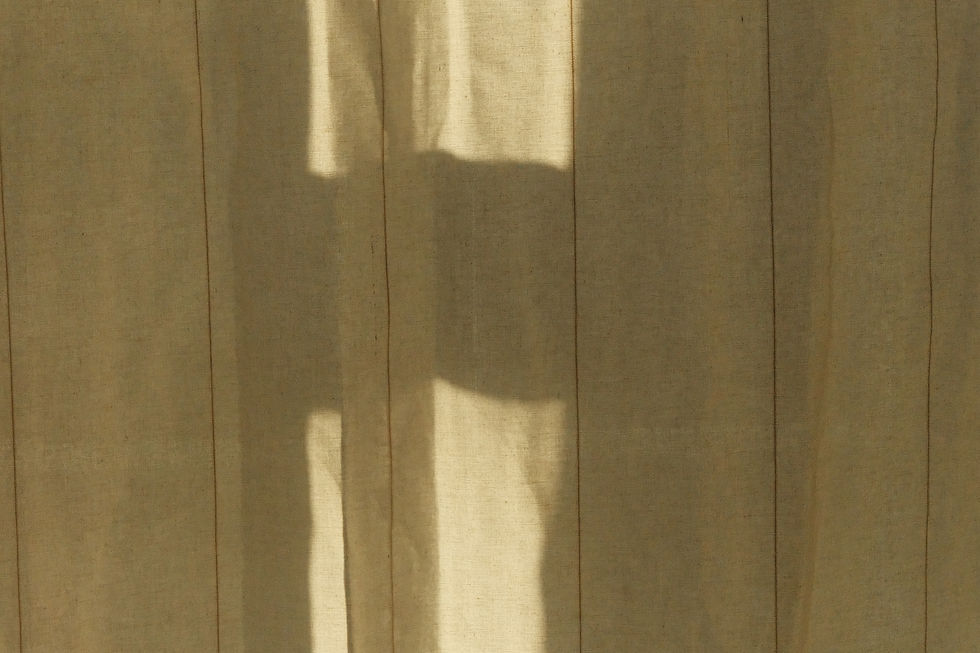 Light filtering through an off/white curtain.