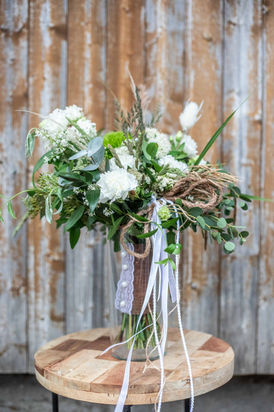 offen gebundener Brautstrauß aus grünen, weißen und braunen Blumen mit Jute-Akzenten