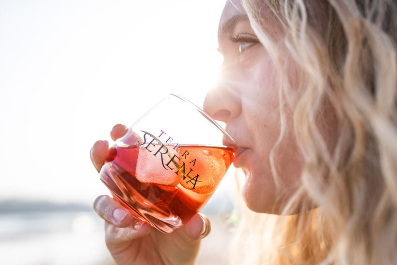 Die Frau trinkt aus einem Glas mit Prosecco gefüllt