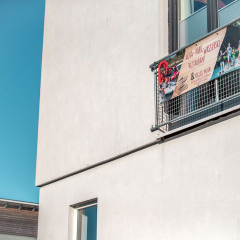 Banner vorm Fenster am französischen Balkon