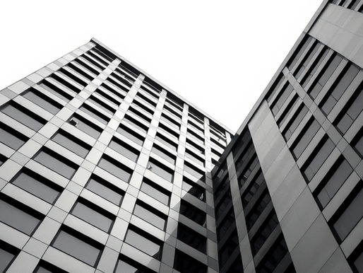 Black and white architectural view of a modern office tower, representing the infrastructure of association mission growth.