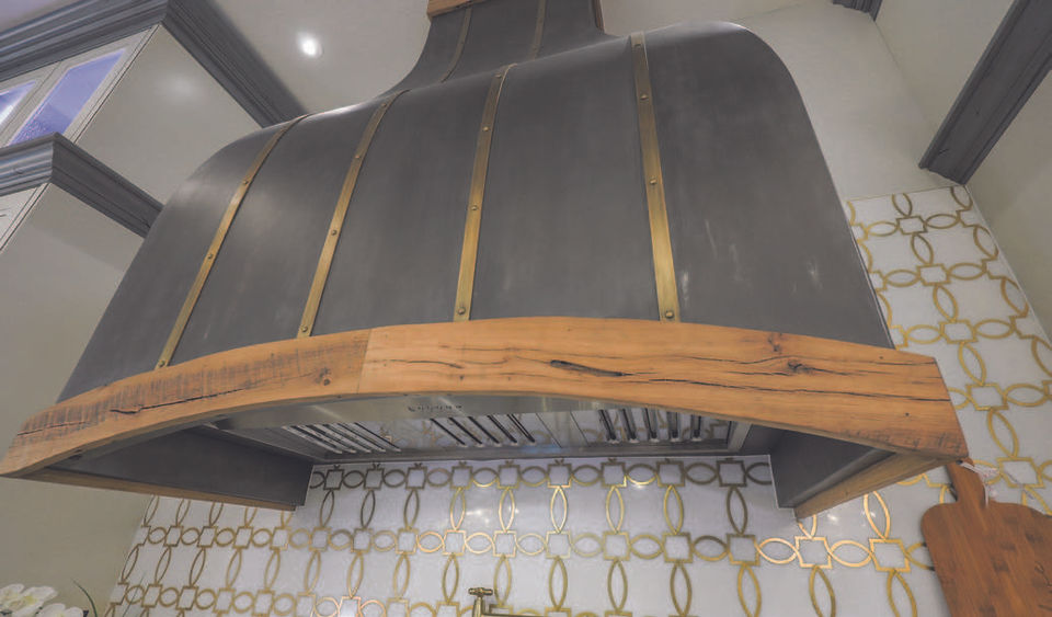 Close up shot of vent hood grey and brass with wood trim