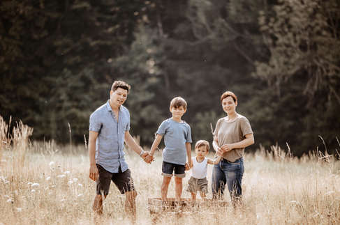 Familienfotograf Luzern Zentralschweiz - Familie steht im hohen Gras.jpeg