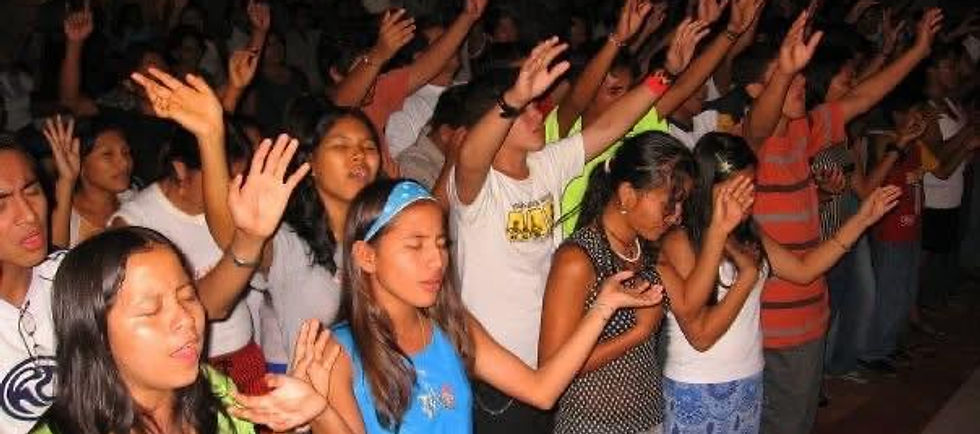 Youth worship scene with a group of young people raising their hands in praise, warm lighting, landscape orientation, suitable for a ministry mission section.