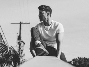 Black and white photo of a man in a white T-shirt and jeans