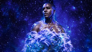 Musical artist Matt B in African clothing against a cobalt blue background of a starry sky.