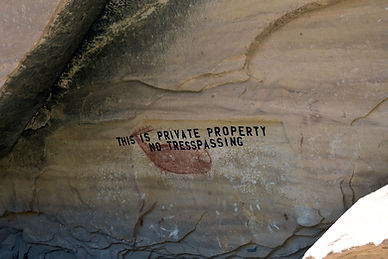 Private property no trespassing sign on a rock wall