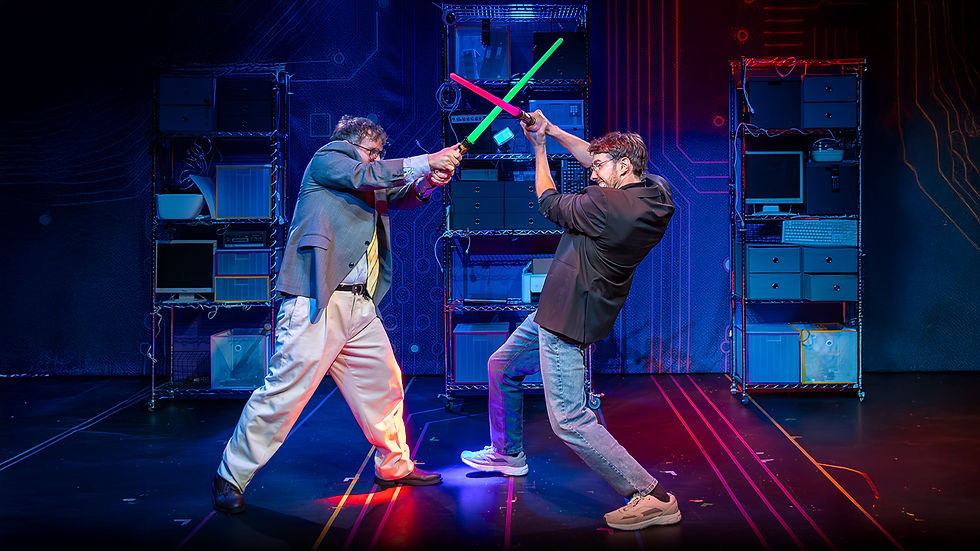 Two men, in office attire, engage in a playful lightsaber duel on a stage with a tech-themed backdrop and colorful lighting.
