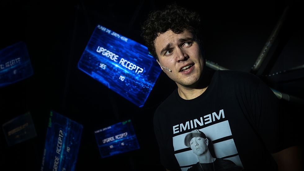 Man with a microphone and an Eminem shirt looks surprised. Blue screens display "UPGRADE, ACCEPT? YES/NO" in a dimly lit setting.