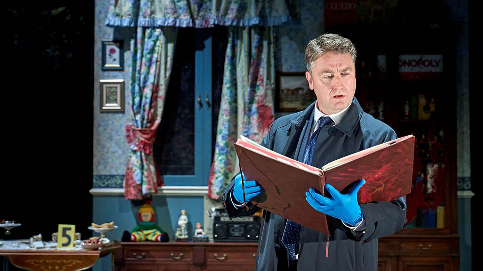 Man in suit and blue gloves examines large book in room with floral curtains and games on shelf. Scene suggests intrigue or investigation.
