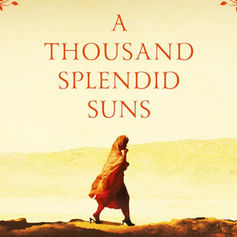 A lone figure in a red dress walks across a desert landscape. Text reads "A Thousand Splendid Suns" with red leaves in corners.