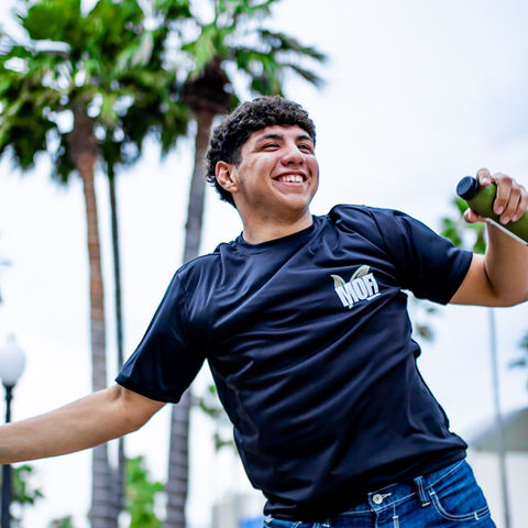Smiling guest holding drink outside MOFI Energy Bar Harlingen