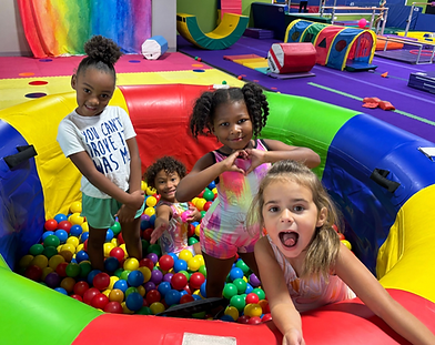Preschool gymnasts playing in ball pit 