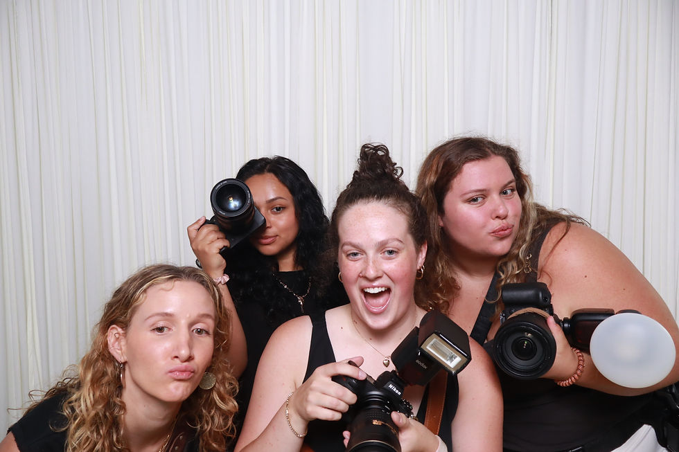 Group of friends posing playfully with cameras during an interactive group photo booth session.