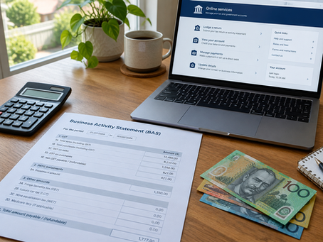 Australian small business owner's desk with a BAS form, calculator, Australian dollar notes and a laptop showing an online tax portal