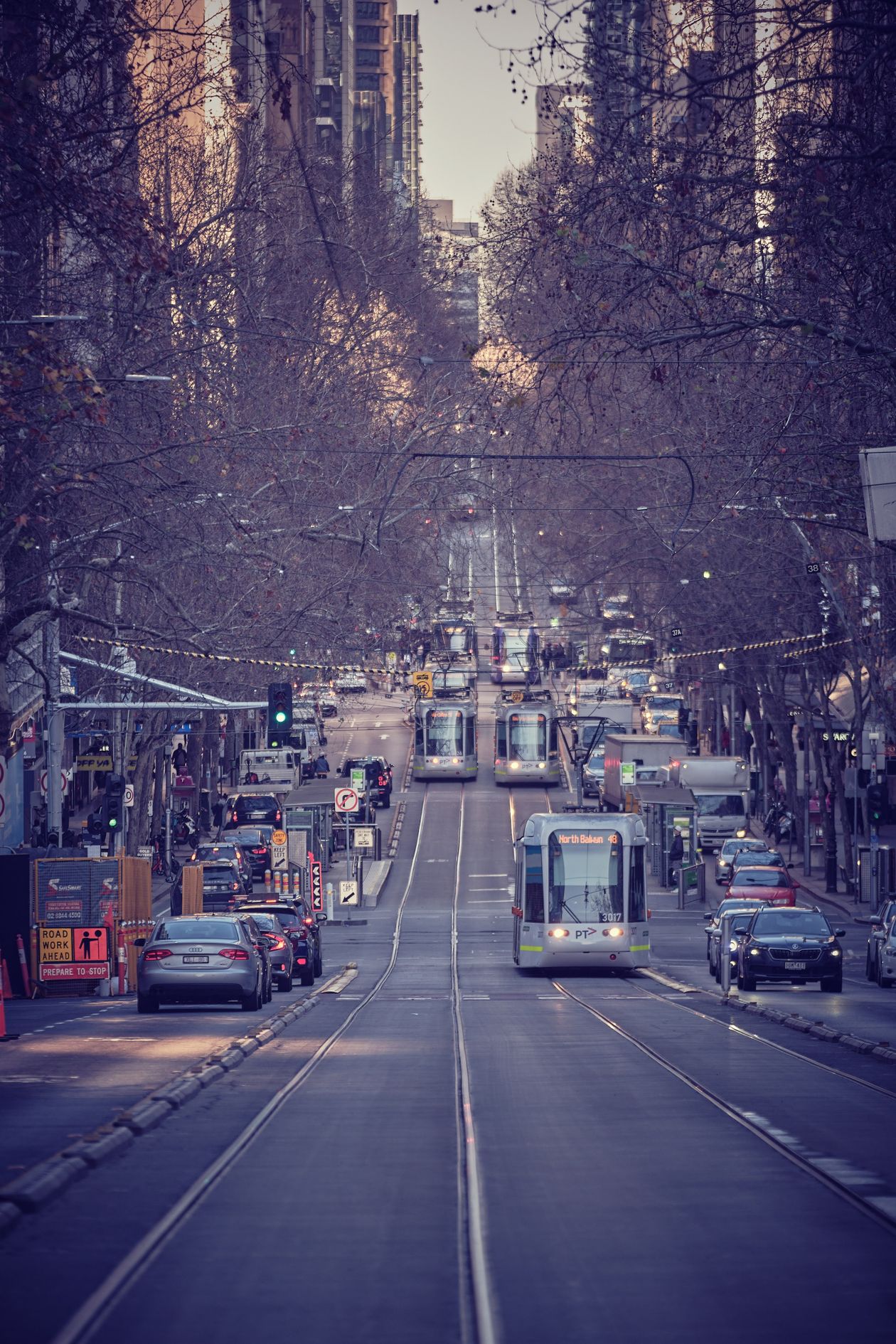 Cars and a tram on a Melbourne street in Australia at dusk