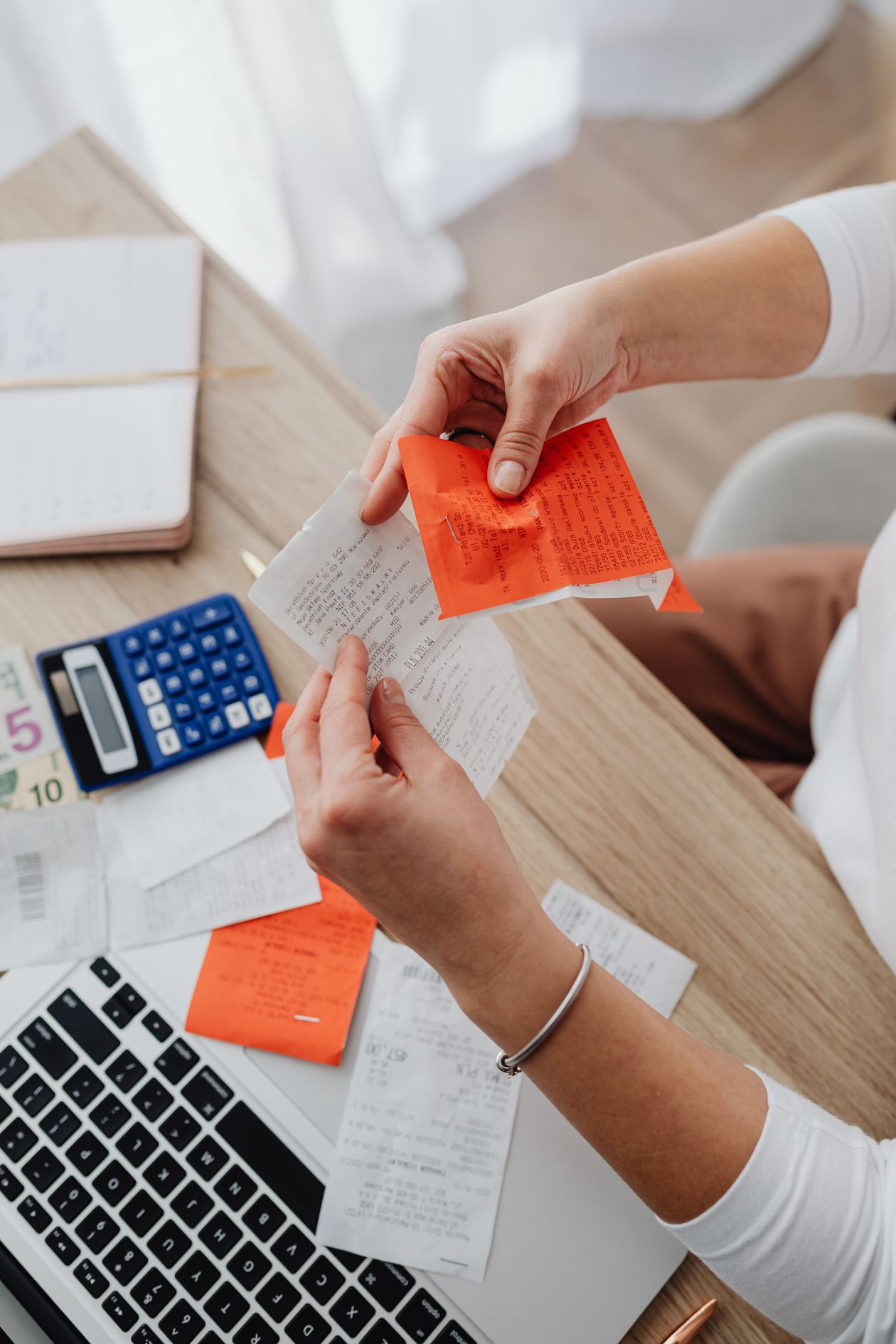 Calculator and receipts laid out on a desk for expense record-keeping