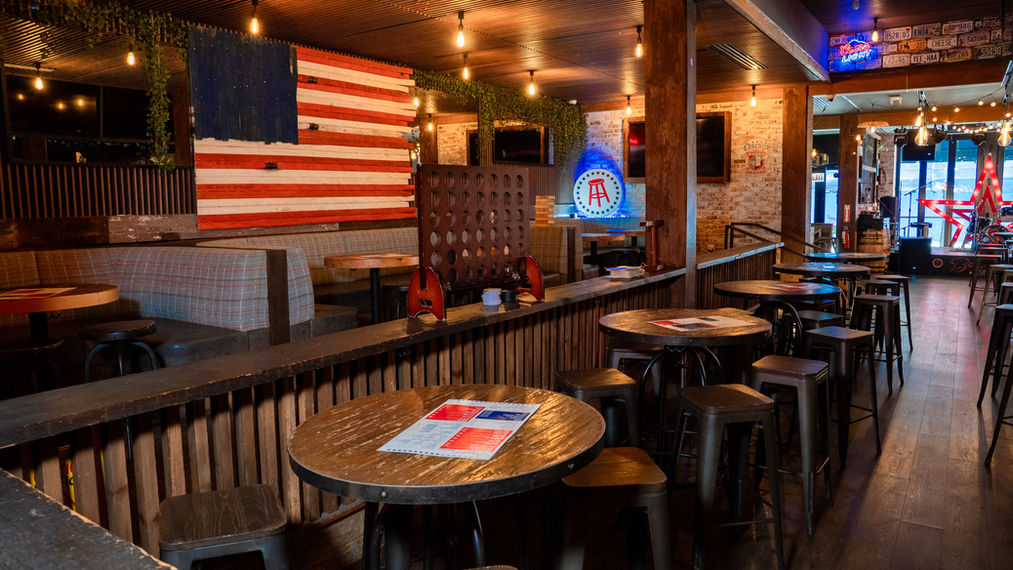 American-flag-themed bar interior with tables and stools