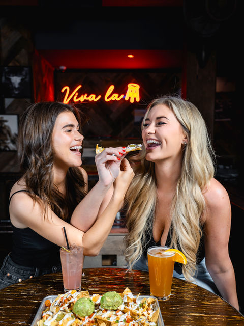 Two women sharing nachos at Viva la Rum