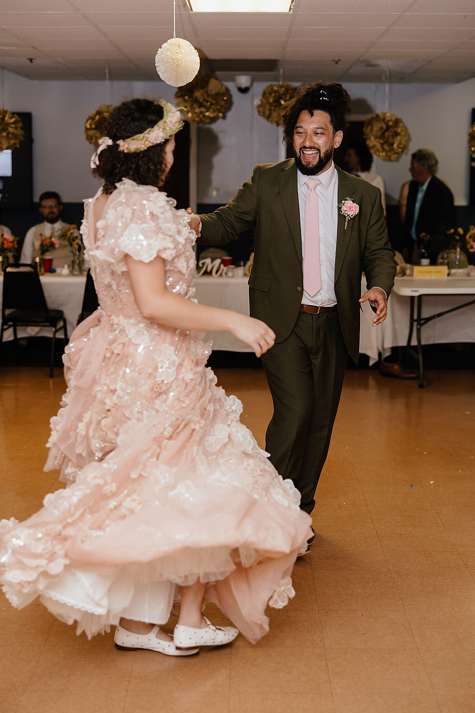 bride in pink floral bridal gown dances with her new husband by Twin Cities photographer
