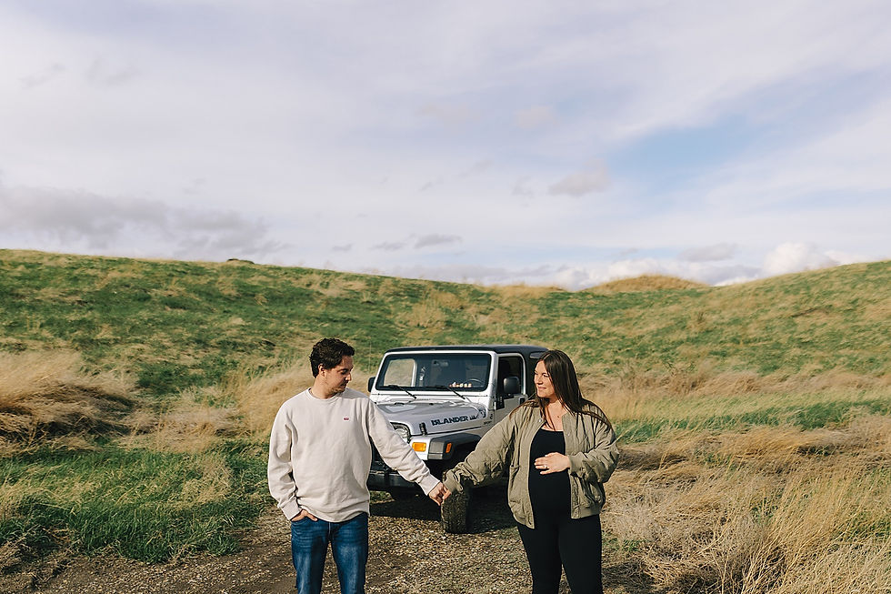 expecting couple hold hands in front of their jeep outside before maternity leave 
