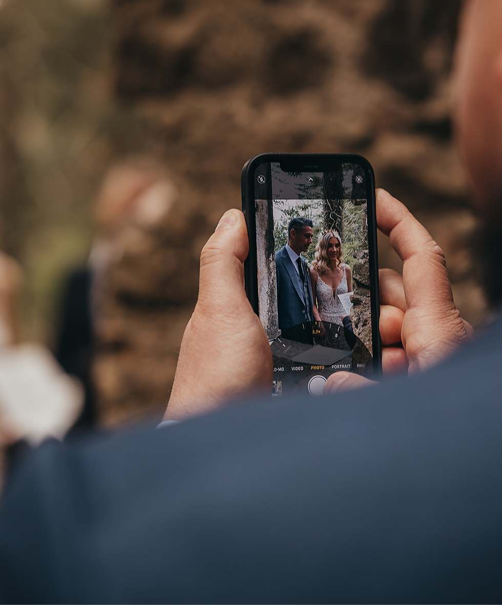 A guest snaps a quick photo of the couple during the ceremony — a beautiful moment, but one that raises the question: should weddings be unplugged? Photo Credit JJMT Photography