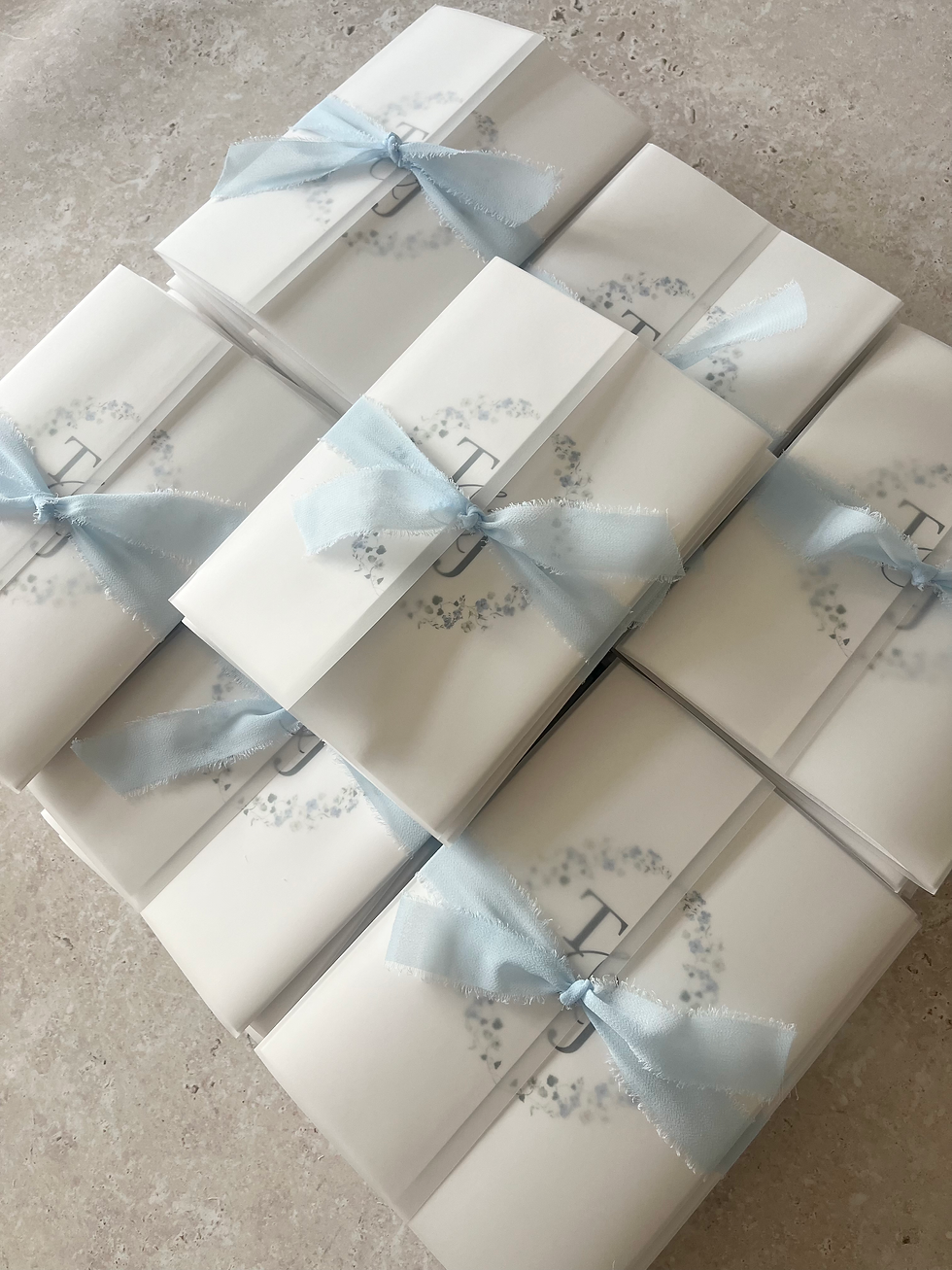Gatefold wedding invitations with soft blue ribbon and dainty blue floral wreath design