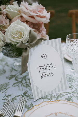Beautiful wedding stationery - table number signs in a stripe design in soft sage green, with green silk bow to finish. 

Photo credit: Jade Greenbrooke Photography