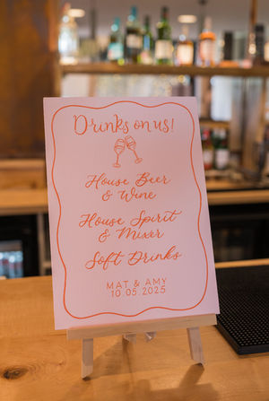 Wedding Drinks menu bar sign. Hand-painted in pale pink with orange  hand-lettering 

Photo credit: Suzanne Lister Photography. 
Shown at Cairns Farm, Edinburgh