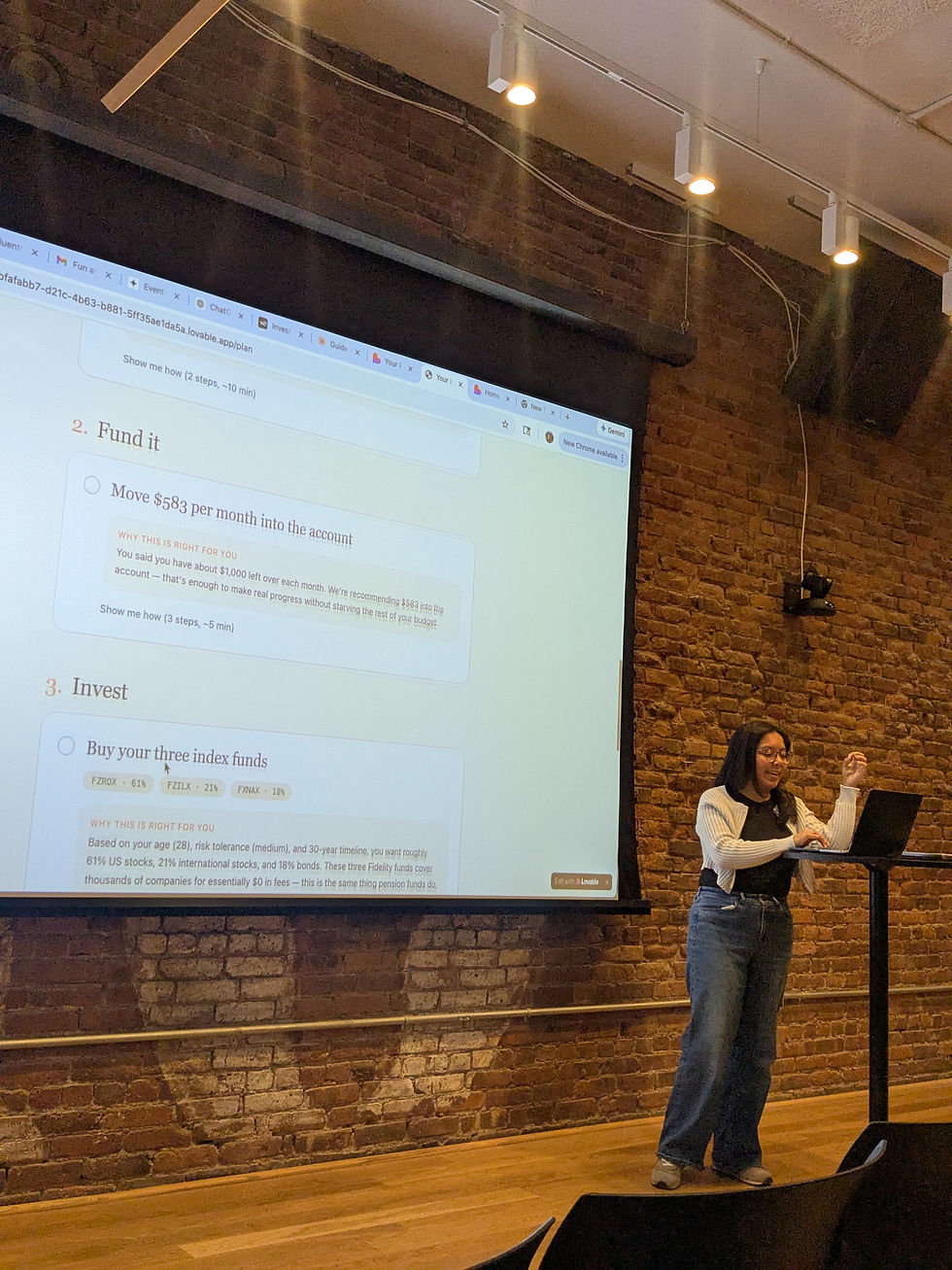Evelin Garcia presents a financial planning app during an AI Snack Club Lovable session, with the app projected on a large screen in an event space with exposed brick walls.