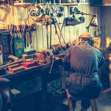 Workman in a vintage garage surrounded by tools